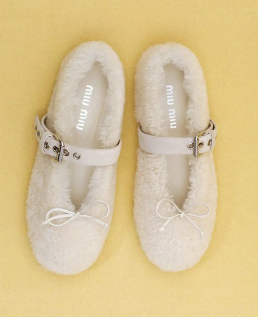 Miu Miu shearling ballet flats on yellow background