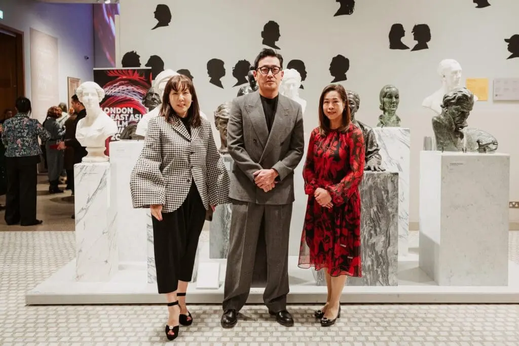 guests posing among marble busts at the gallery