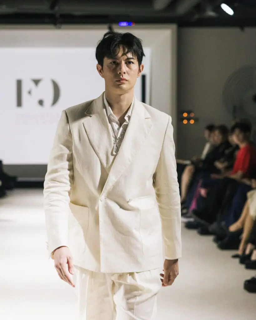 Close-up of model Joel Jay Lane wearing Francesca Cottone white blazer