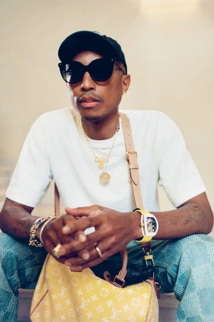 Pharrell Williams wearing Louis Vuitton bag and sunglasses