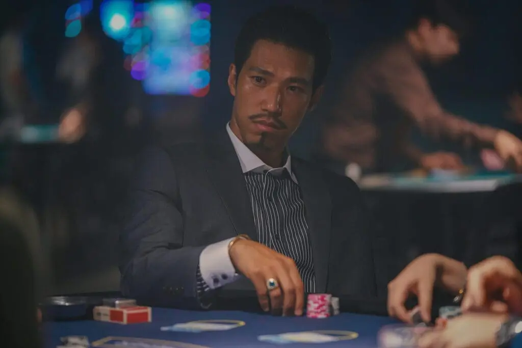 Actor in suit playing poker at casino table