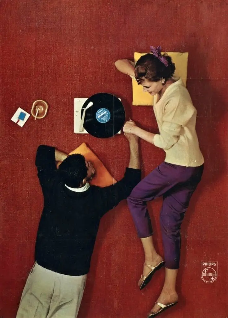Vintage couple listening to vinyl record on floor