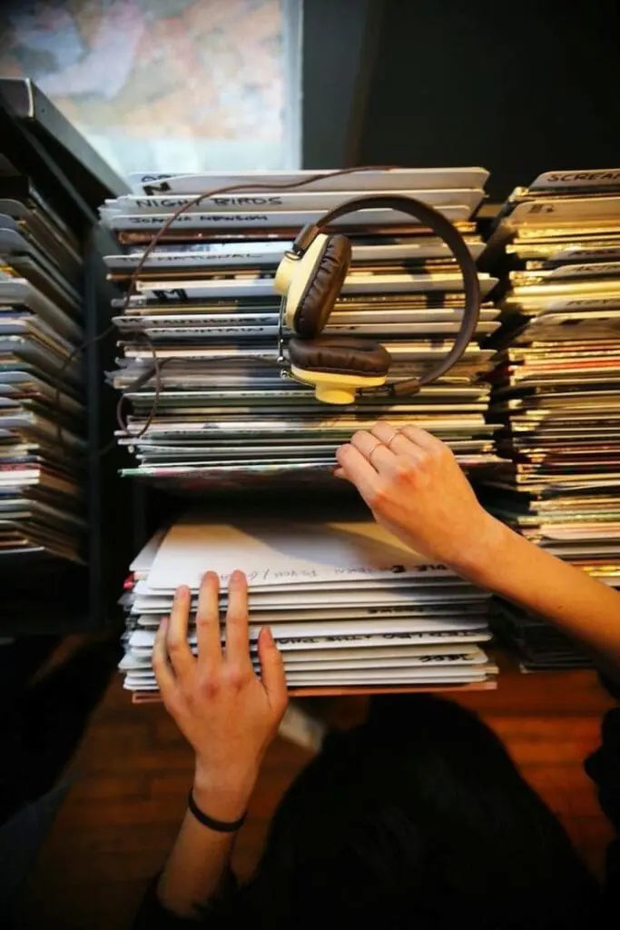 Hands browsing vinyl records with headphones on top