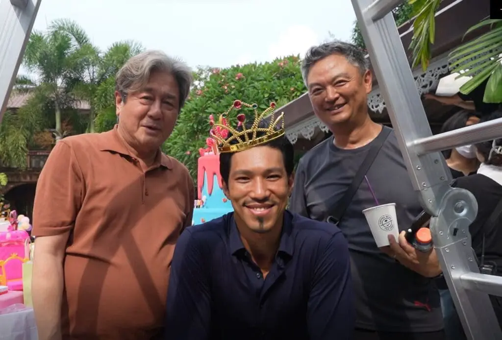 Yoon-sung Kang smiling with cast during a break on set