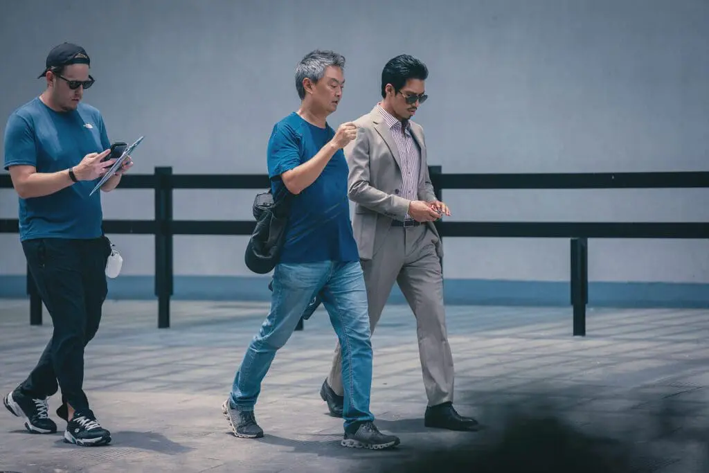 Yoon-sung Kang and actor Min Kim in discussion during filming