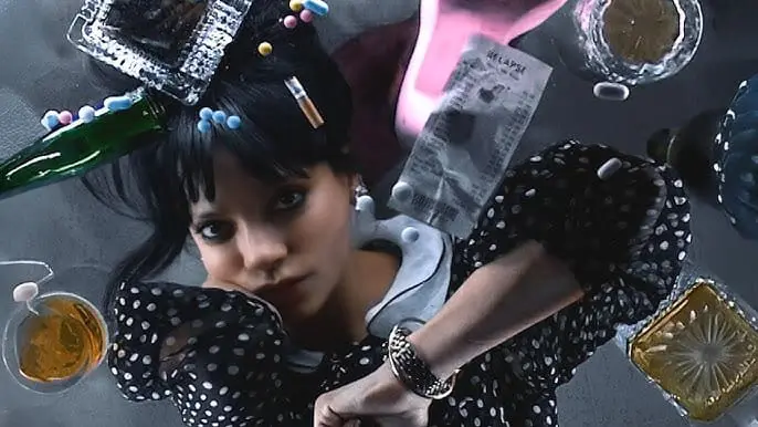 Lily Allen under a glass table with drinks, reflective gaze