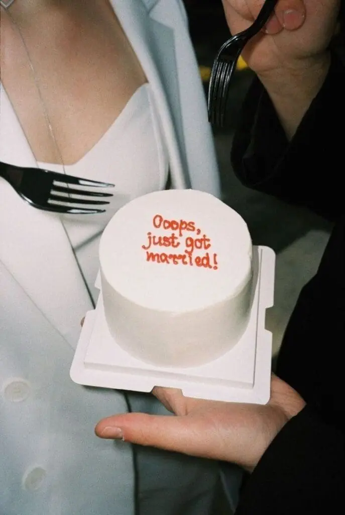 mini wedding cake with “Oops, just got married” text