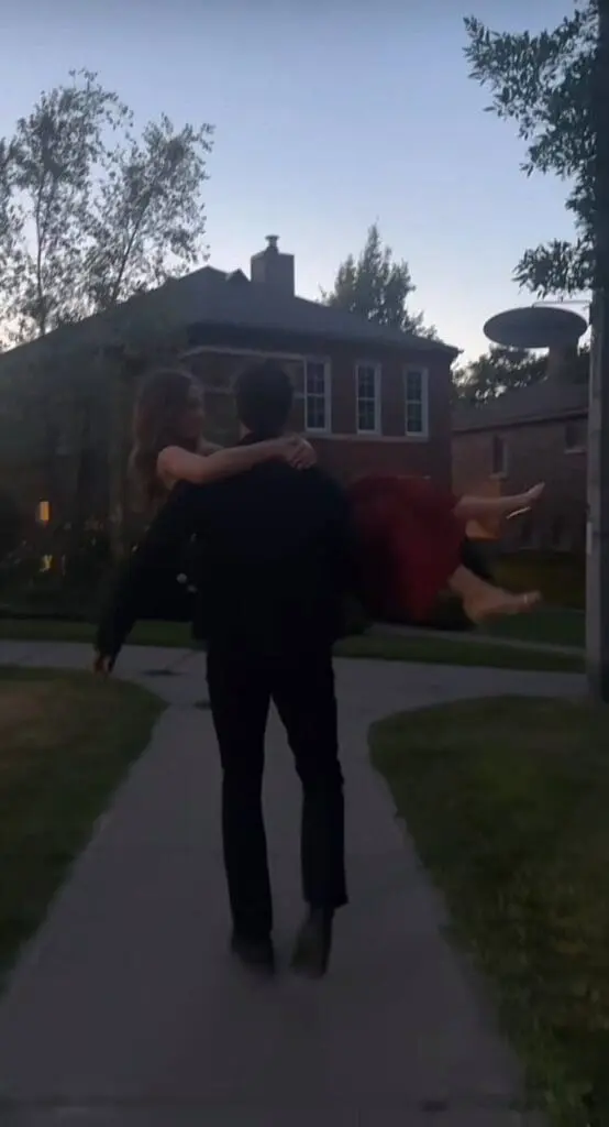 person lifts partner on path in a playful romantic pose