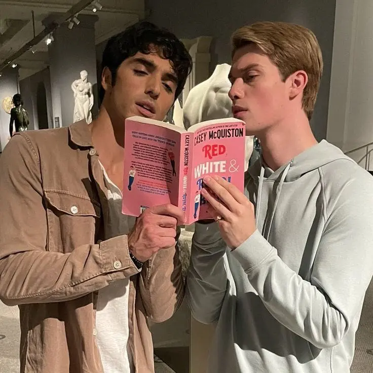 two readers holding a pink romance book together