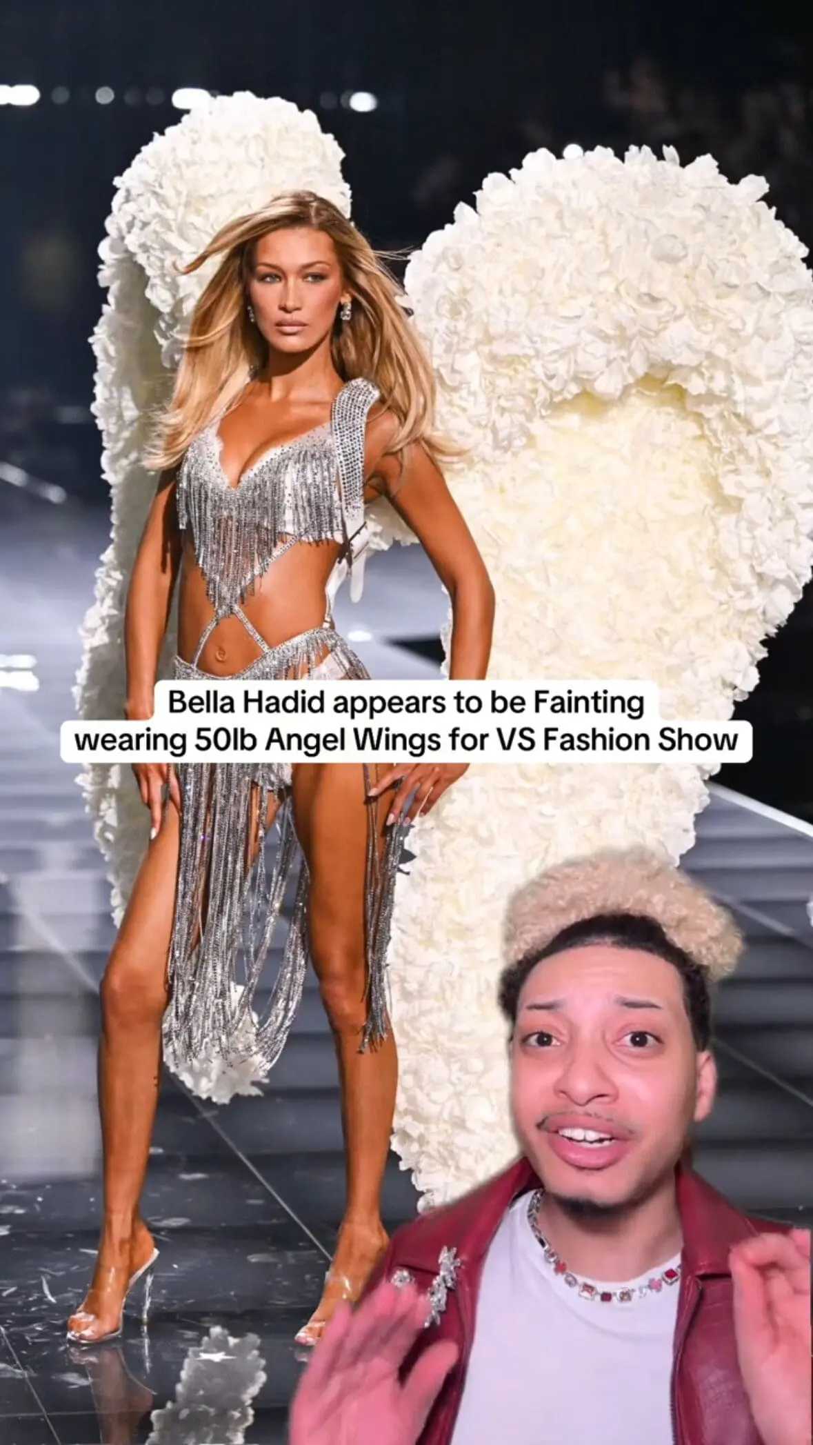 runway model in silver dress with oversized white wings and commentary overlay