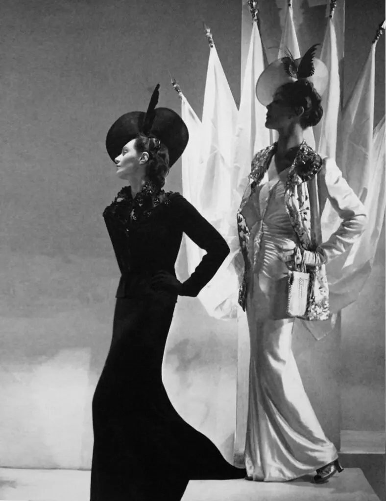 Black-and-white couture photo with two models in sculptural hats