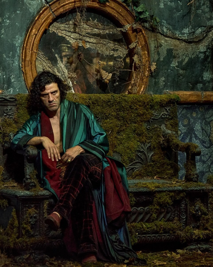 Victor in a green silk robe on a mossy throne from Guillermo del Toro’s Frankenstein