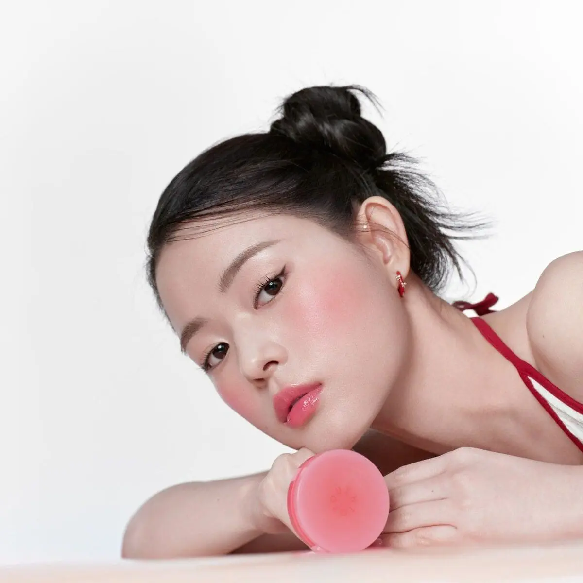 K-beauty portrait with soft pink blush and compact