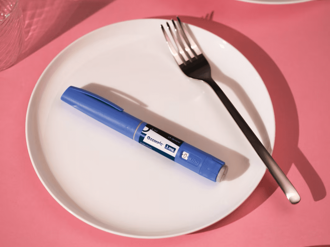 Ozempic pen on plate pink background editorial