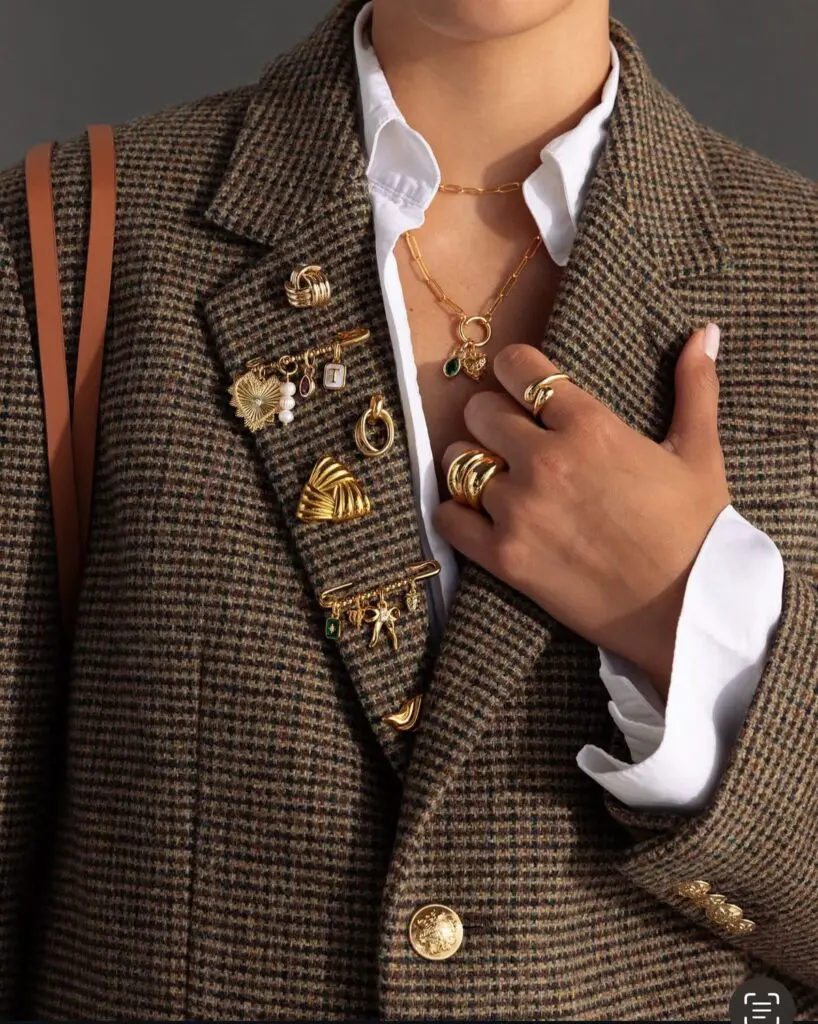 Brooched tweed blazer with layered gold jewelry