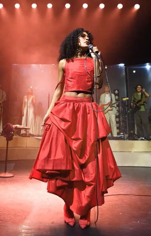 Olivia Dean live in red two-piece outfit holding microphone