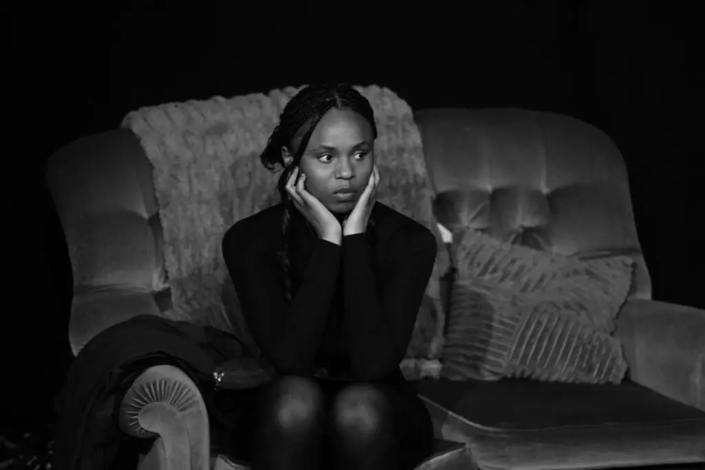 Performer seated alone in reflective unscripted moment