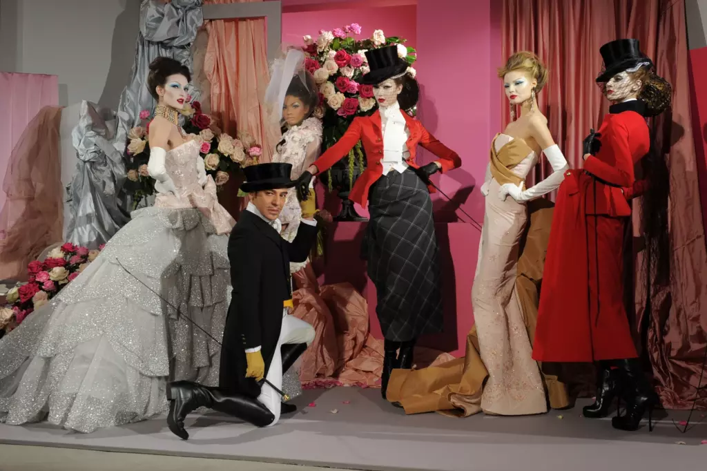 John Galliano poses backstage with top-hat-clad models in a Dior couture tableau