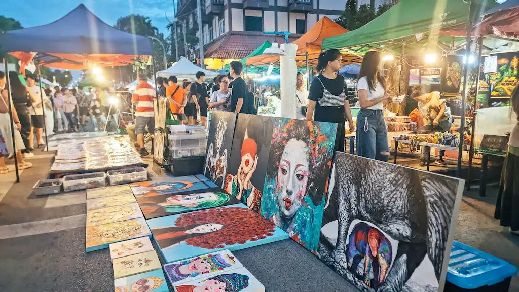 Open-air art market with portrait paintings at dusk