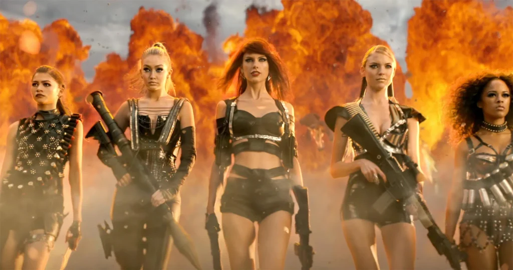 stylized pop video scene with women, flames and prop weapons
